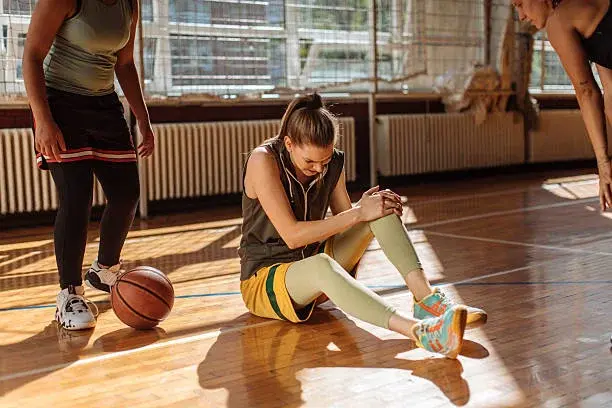 The female athlete who was injured while sitting on the sports wood floor The female athlete who was injured while sitting on the sports wood floor